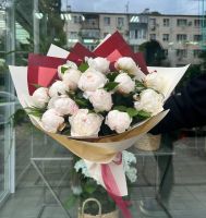 Букет из 15 белых пионов в упаковке с зеленью